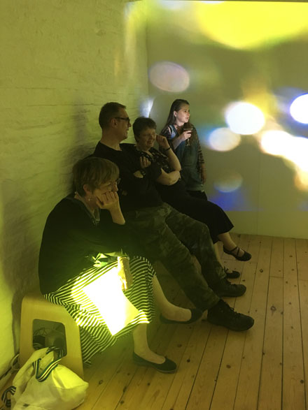 People watching gallery with images projected onto the walls